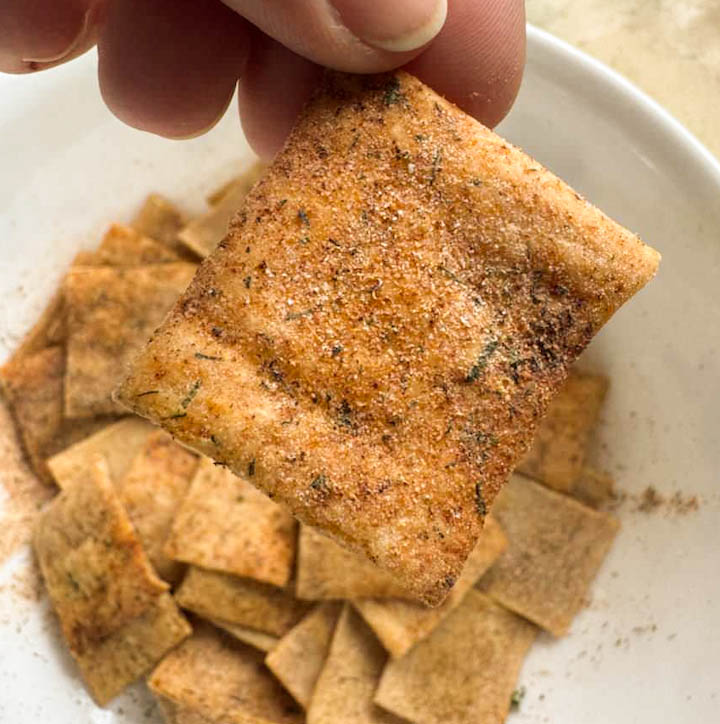 Hand holding sourdough discard cracker